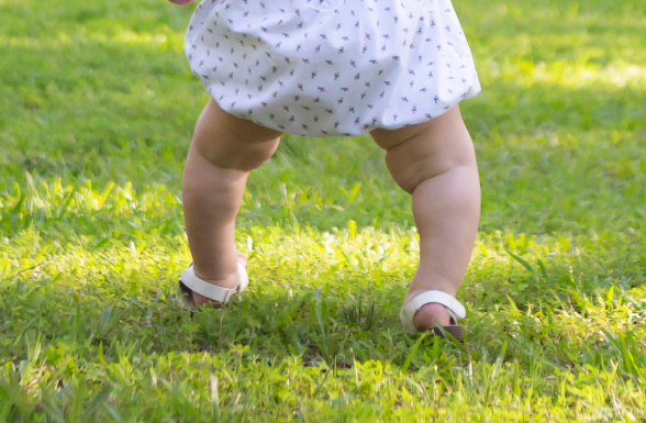 Legs of Isla, a young child living with XLH, walking on a lawn